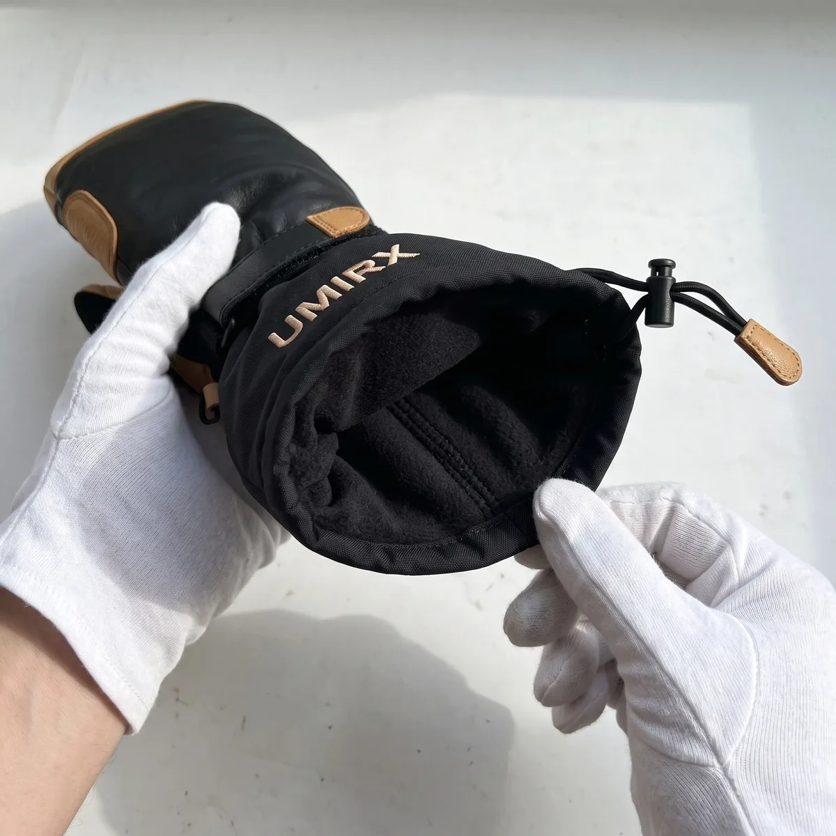 Inside of a ski mitten, insulated lining, held in white gloves