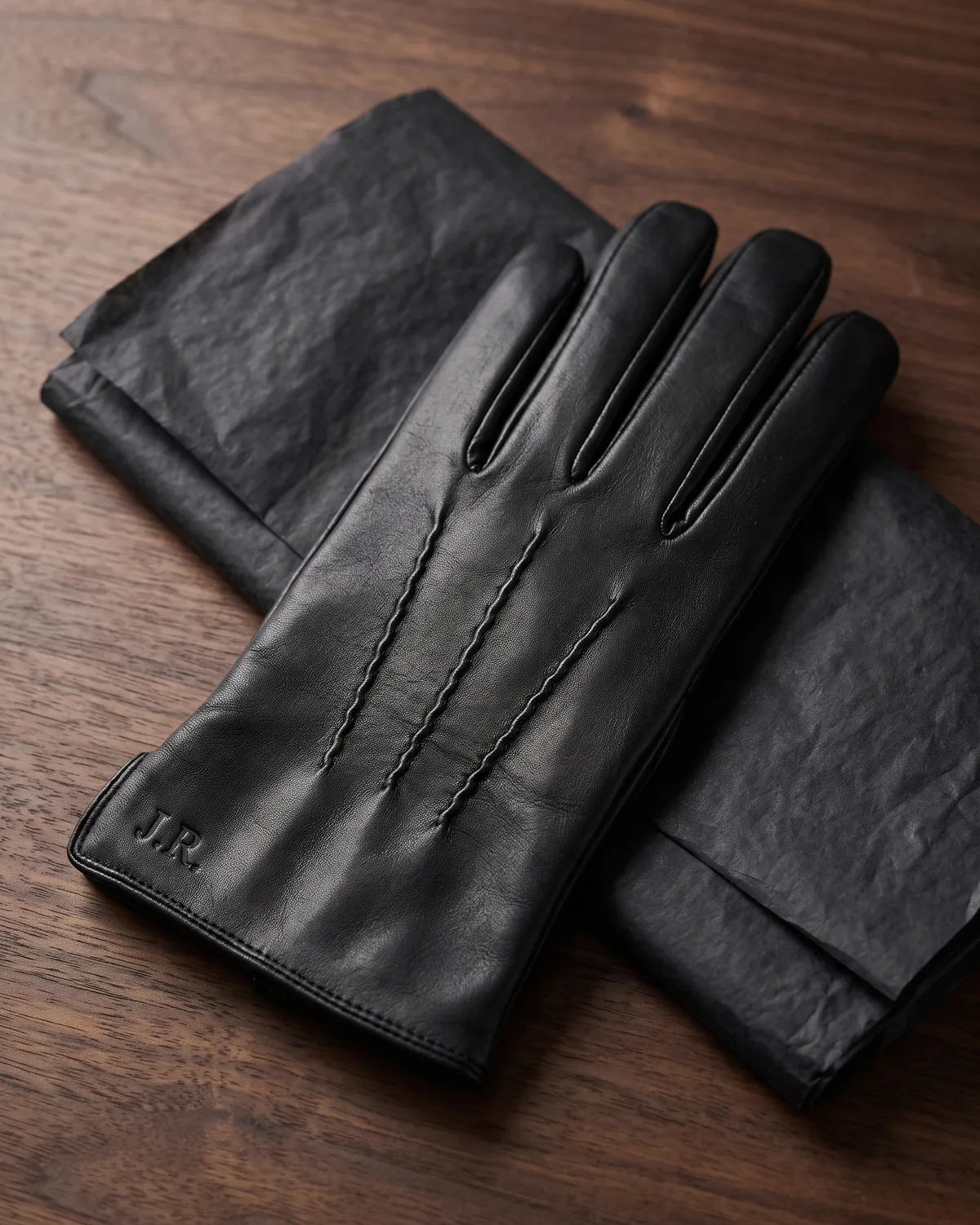 Logo embossed into a tan leather glove cuff
